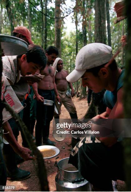 Men break for lunch February19, 2001 as they work on the the constuction of a camp near El Venado, Colombia, that will serve as a home to some 70...