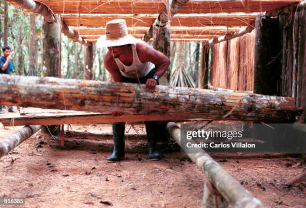 Man works February19, 2001 on the the constuction of a camp near El Venado, Colombia, that will serve as a home to some 70 people convicted of crimes...