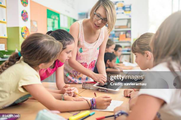 insegnante che mostra tablet pc agli studenti in classe - school boy girl foto e immagini stock