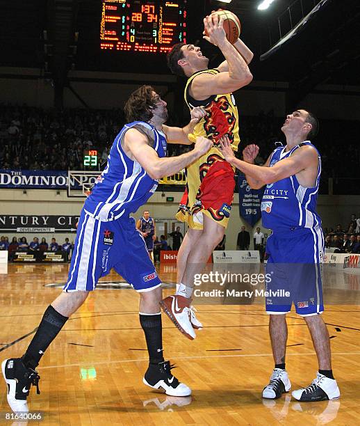 Puke Lendon of the Pistons jumps for the hoop with Troy McLean and Kevin Owens in defence during game two of the NBL Finals series between the...