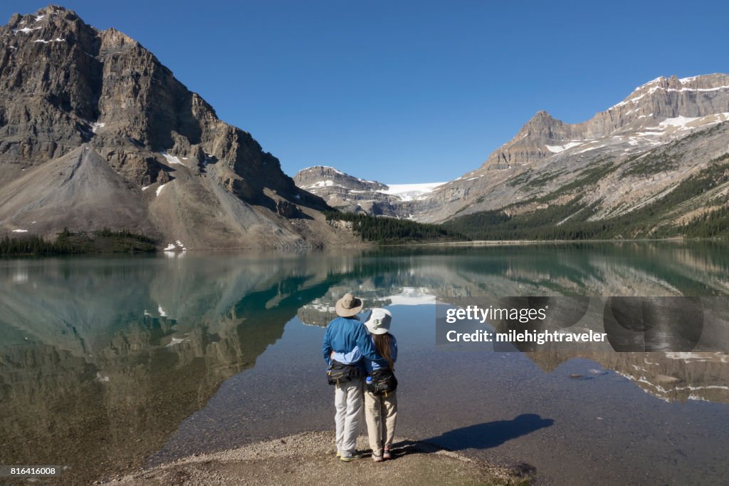 Woman man couple enjoy Bow Lake reflections Banff National Park Alberta Canada glacier