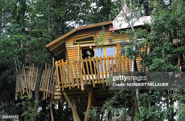 Mareike waves from the window of a new tree house built at the so-called "Kulturinsel Einsiedel" theme park and presented to the public on June 20,...