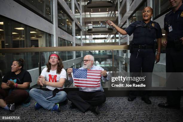 Capitol Police officer asks protesters to leave the area around the office of Sen. Dean Heller in the Hart Senate Office Building on July 17, 2017 in...