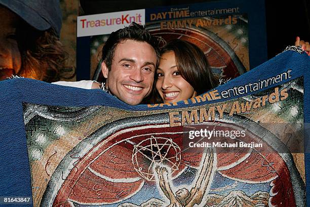 Actors Daniel Goddard and Christel Khalil pose with products by Treasureknit.com in the Daytime Emmy official gift lounge produced by On 3...