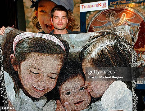 Actor Daniel Cosgrove poses with products by Treasureknit.com in the Daytime Emmy official gift lounge produced by On 3 Productions held at the Kodak...