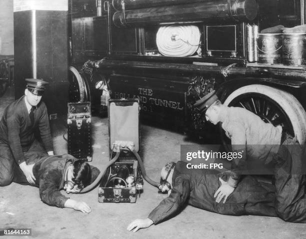 Firemen using a Davis Inhalator with a double breathing bag for two victims, in the Holland Tunnel, New York, circa 1930.