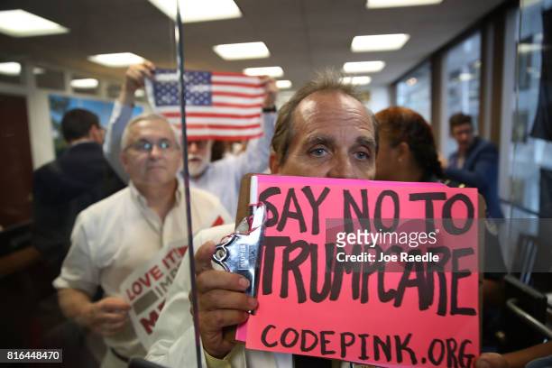Protesters walk out of the office of Sen. Dean Heller in the Hart Senate Office Building on July 17, 2017 in Washington, DC. The protesters were...