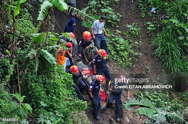 Firefighters remove the body of a man killed in a mudslide at a garbage dump in Guatemala City on June 20, 2008. At least seven people died and 20...