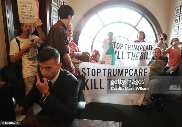 Senate Staff Assistant Dave Straka takes phone calls as protesters occupy the office of Sen. Rob Portman inside the Russell Senate Office Building on...