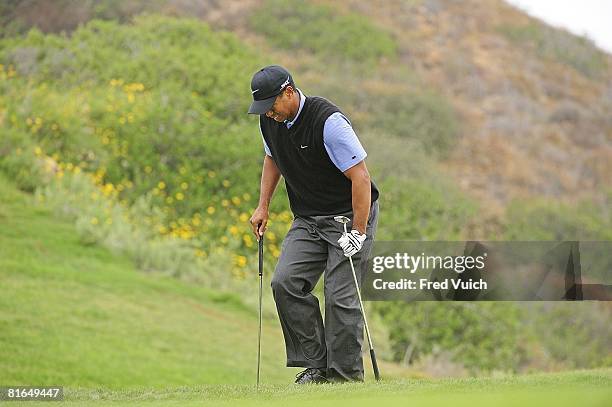 Tiger Woods getting out of bunker on No. 3 with help of two golf clubs during Saturday play at Torrey Pines GC. Woods had arthroscopic surgery on his...