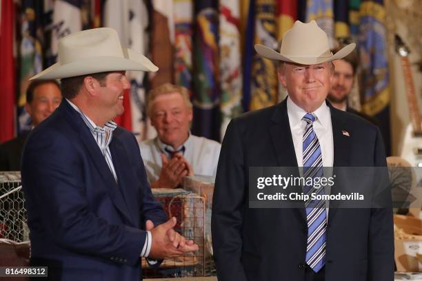 President Donald Trump wears a Stetson cowboy hat given to him by Dustin Noblitt while touring a Made in America product showcase in the East Room of...