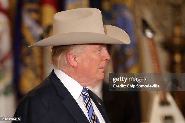 President Donald Trump wears a Stetson cowboy hat while touring a Made in America product showcase in the East Room of the White House July 17, 2017...