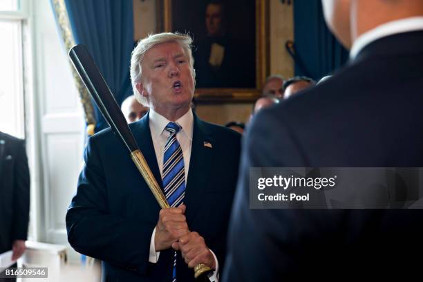 President Donald Trump holds a baseball bat while participating in a Made in America event with companies from 50 states featuring their products in...