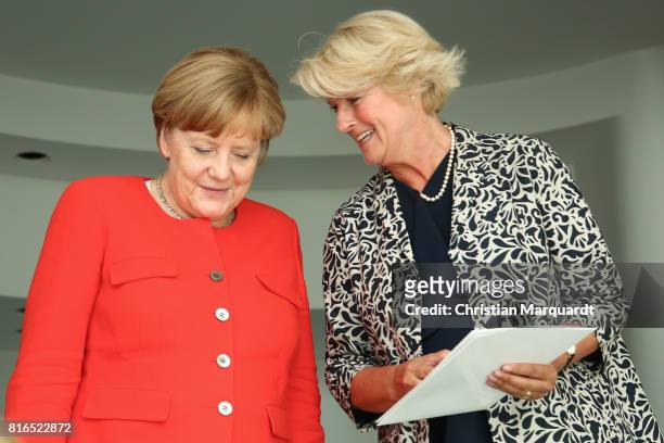 Monika Gruetters is seen handing out a document for Angela Merkel as she attends the '#weiles2017ist' Reception And Closing Ceremony at...