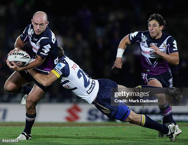 Matt Geyer of the Storm is tackled by John Williams of the Cowboys during the round 15 NRL match between the Melbourne Storm and the North Queensland...