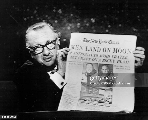 Anchor Walter Cronkite holds up The New York Times during the Apollo 11 telecast, July 20, 1969 at 10:11 PM.