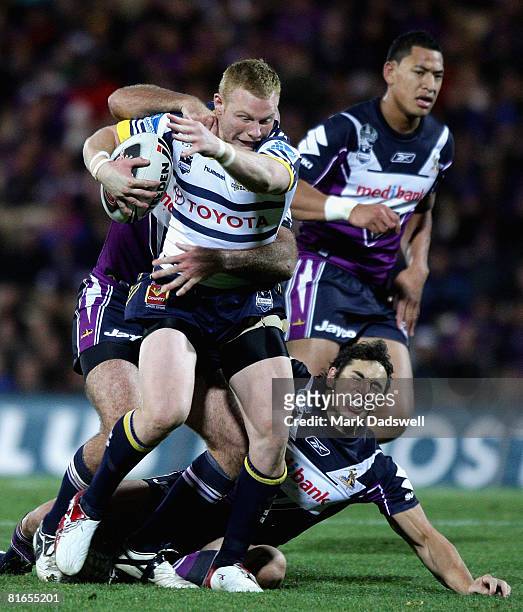 Anthony Watts of the Cowboys is tackled during the round 15 NRL match between the Melbourne Storm and the North Queensland Cowboys at Olympic Park on...
