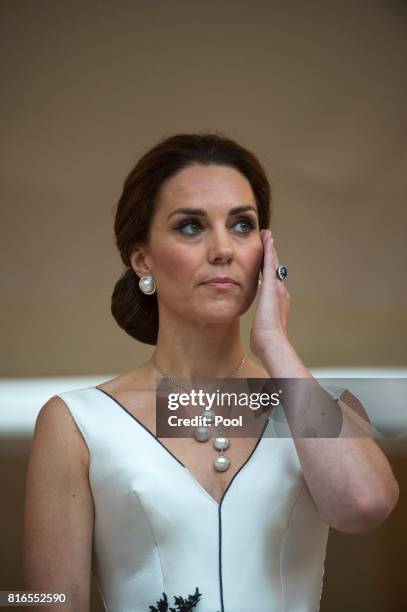 Catherine, Duchess of Cambridge listens as Prince William, Duke of Cambridge gives a speech during the Queen's Birthday Garden Party at the Orangery...