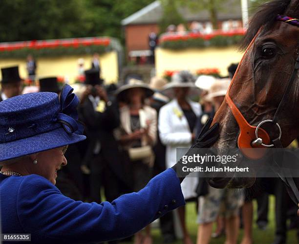 Queen Elizabeth II greets her horse Free Agent after it landed The Chesham Stakes Race run at Ascot Racecourse on June 21 in Ascot, England. Today...