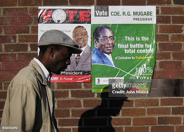 Campaign posters for President Robert Mugabe , and opposition leader Morgan Tsvangirai , are posted on a grocery store wall June 21, 2008 in...