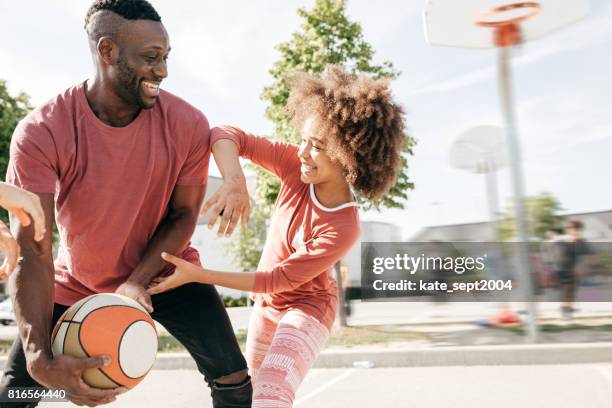 Dad playing basketball with daughter