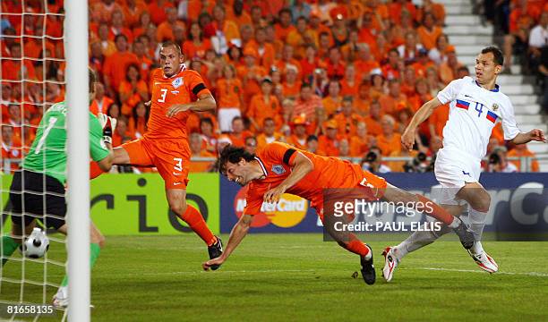 Dutch forward Ruud van Nistelrooy scores past Russian goalkeeper Igor Akinfeev , Russian defender Sergei Ignashevich and Dutch defender John Heitinga...
