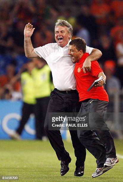 Russia's national football team's Dutch coach Guus Hiddink celebrates with assistant coach Igor Korneev after forward Andrei Arshavin scored his...