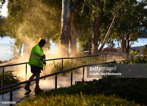 Council worker is seen water blasting a concrete wlkway along the banks of the Fitzroy river on July 12, 2017 in Rockhampton, Australia