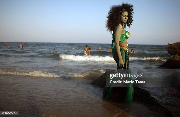 Reveler dressed as a mermaid poses for a photo at the 25th annual Coney Island Mermaid Parade June 21, 2008 in the Brooklyn borough of New York City....