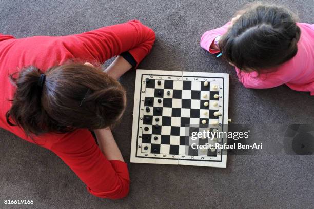 mother and daugther play chess together - chess board overhead stock pictures, royalty-free photos & images