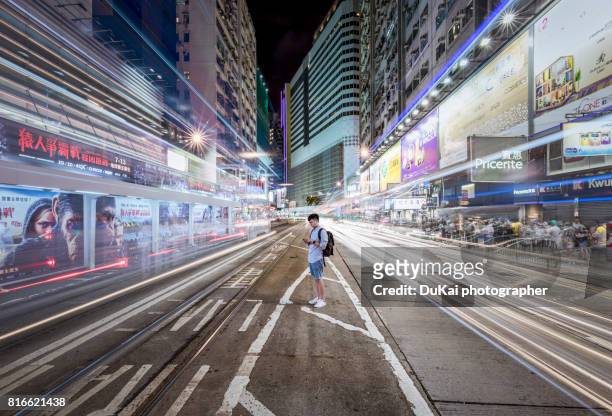 young man using smart phone in city street at night - hong kong street 個照片及圖片檔