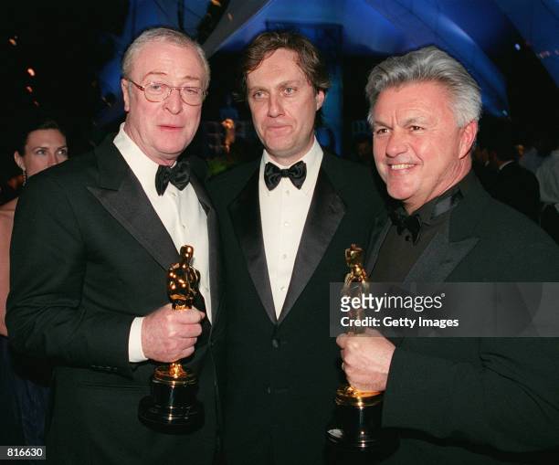 Left to right, recipient of Best Supporting Actor, Michael Caine, director Lasse Hallstrom and John Irvin, recipients for Best Screen Play for the...