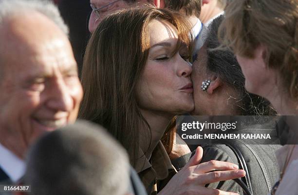 French First Lady Carla Bruni-Sarkozy kisses French philosopher and Holocaust survivor Simone Weil near Israeli President Shimon Peres during a...