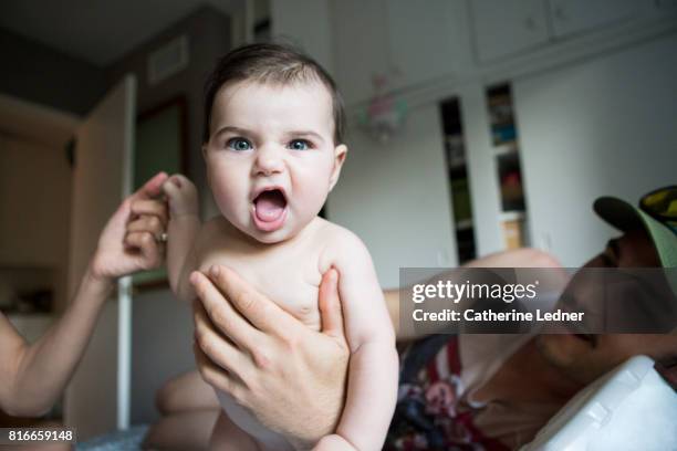 six month old baby making a face - bébé grimace photos et images de collection