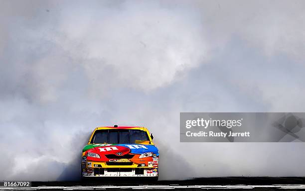 Kyle Busch, driver of the M&M's Toyota burns his tires after winning the NASCAR Sprint Cup Series Toyota/Save Mart 350 at the Infineon Raceway on...