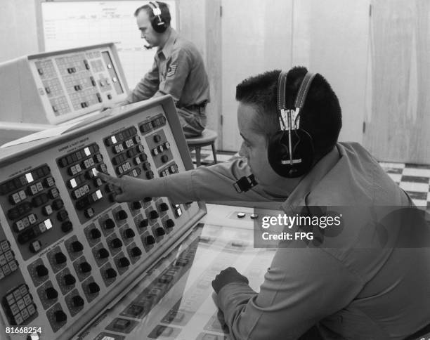 Instructor Lt. Richard C. Reynolds programmes a malfunction into the launch control trainer used in the Titan missile supervisors' and planners'...