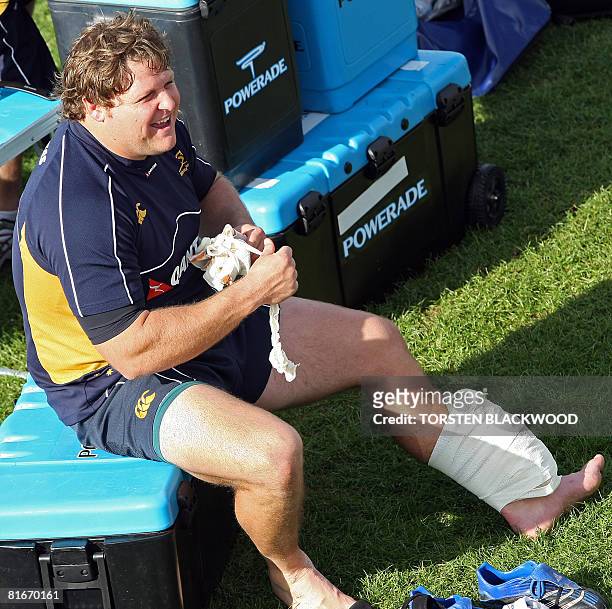 Wallabies prop Matt Dunning nurses his injured left leg with an ice pack during the rugby union team's first training session by Sydney's Coogee...