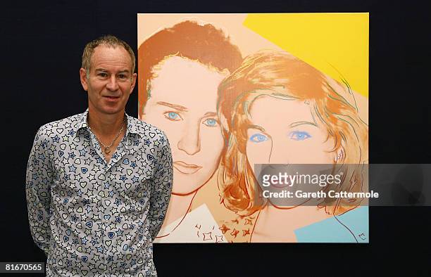 Former tennis player John McEnroe poses next to a 'Portrait of John McEnroe and Tatum O'Neal 1986' by Andy Warhol at Sotheby's on June 23, 2008 in...