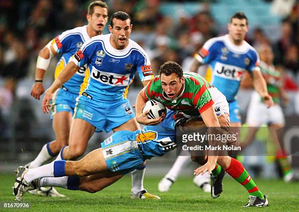 Ben Lowe of the Rabbitohs is tackled during the round 15 NRL match between the South Sydney Rabbitohs and the Gold Coast Titans at ANZ Stadium on...