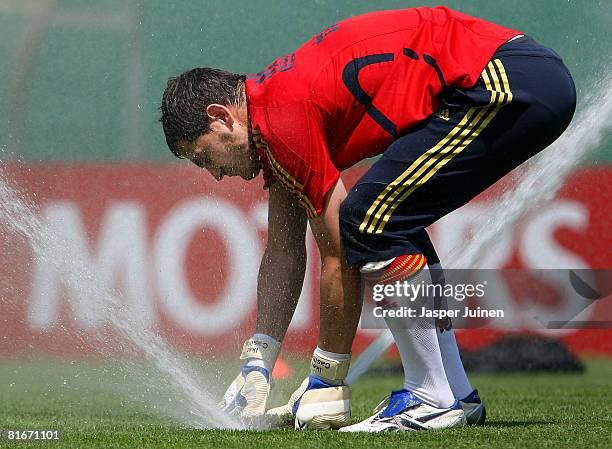 Goalkeeper Iker Casillas of Spain tries to put off a sprinkler during a light training session the day after his quarter-final match at the Kampl...