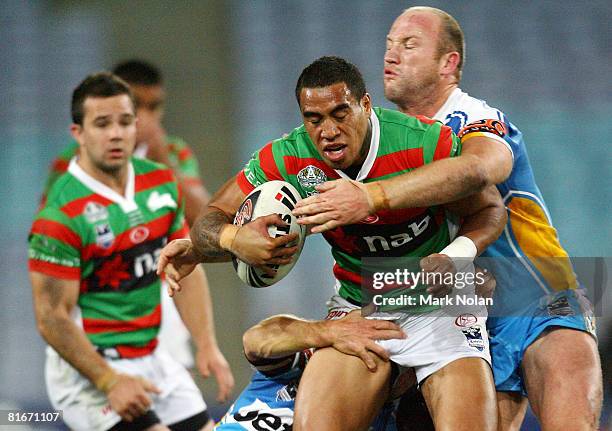 Manase Manuokafoa of the Rabbitohs is tackled by Luke Bailey of the Titans during the round 15 NRL match between the South Sydney Rabbitohs and the...