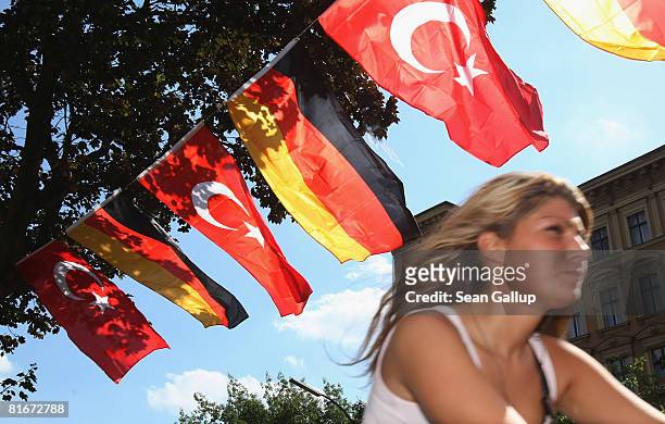 Young woman rides her bicycle past German and Turkish flags fluttering between lamp posts in the immigrant-heavy district of Kreuzberg two days ahead...