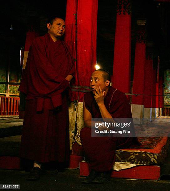 Monks sit and wait for foreign journalists to visit the Sera monastery on June 22, 2008 in Lhasa, Tibet, China. Chinese authorities have maintained...