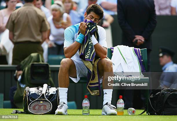 Novak Djokovic of Serbia takes a break between games during the men's singles round one match against Michael Berrer of Germany on day one of the...