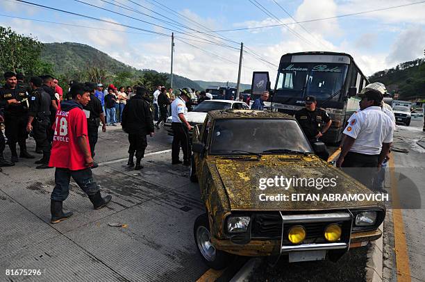 Firefighters and policemen look at damaged vehicles in front of a plant located in the route to the Atlantic Ocean -km 18, in Guatemala City where a...
