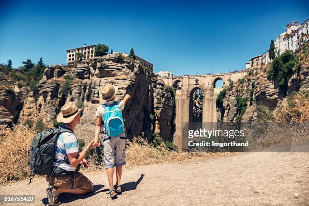 father and sun admiring puente nuevo in ronda, spain - andaluzia stock pictures, royalty-free photos & images