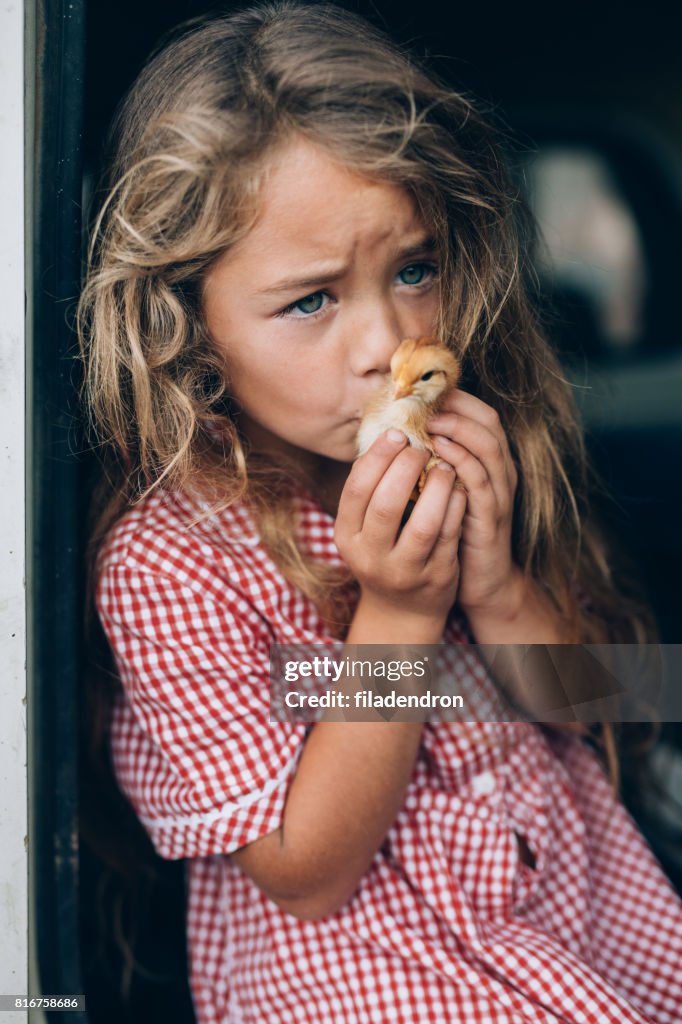 Girl kissing a little chicken