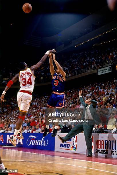 John Starks of the New York Knicks has his three-point shot blocked by Hakeem Olajuwon of the Houston Rockets in Game Six of the 1994 NBA Finals at...