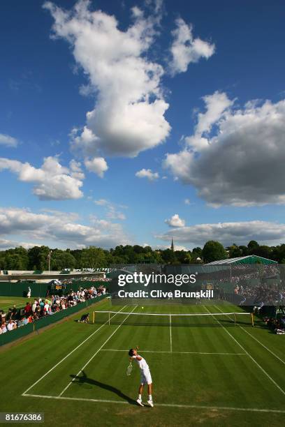 Yen-Hsun Lu of Taiwan, Province of China serves during the men's singles round one match against Florent Serra of France on day one of the Wimbledon...