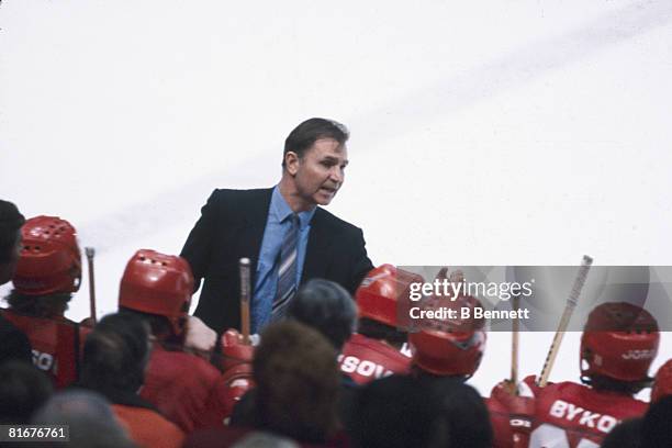 Russian ice hockey coach Viktor Tikhonov talks to his players who sit on the bench, January 1983.